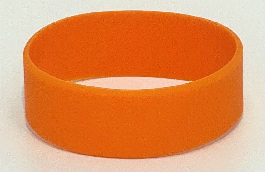 A close up of an orange bracelet on a white surface