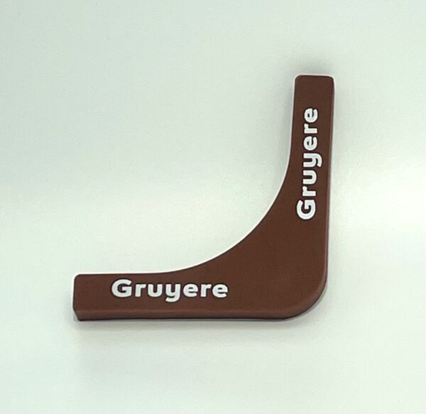 A brown wooden object with the word gruyere written on it.