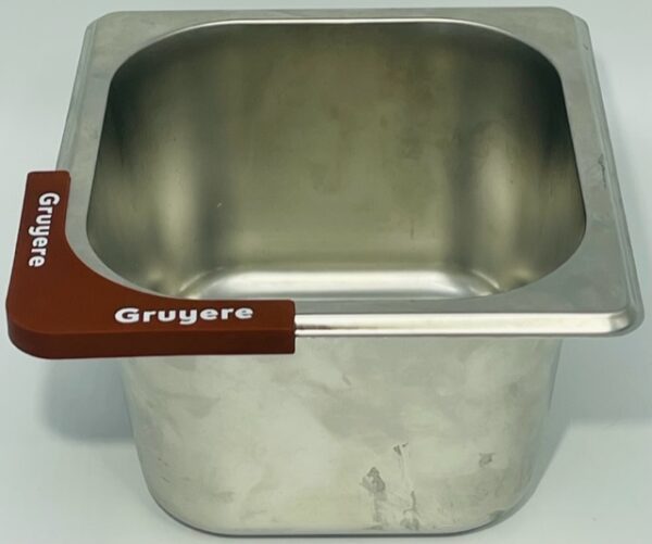 A metal pan with a red handle on top of it.