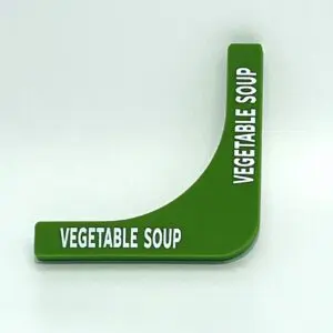 A green vegetable soup sign on top of a table.