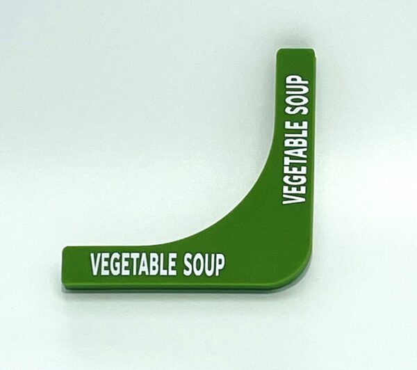 A green vegetable soup sign on top of a table.