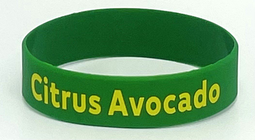 A green wristband with the words citrus avocado on it.