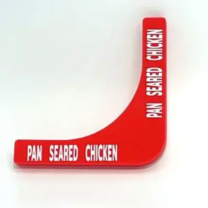 A red sign with the words pan seared chicken written on it.
