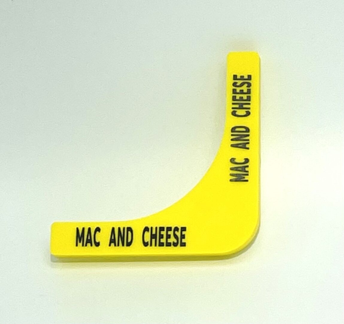 A yellow plastic object with the words mac and cheese written on it.