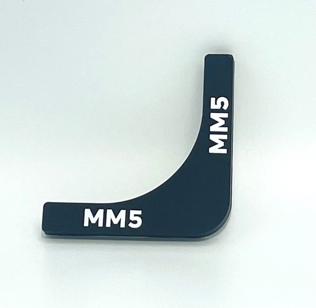 A black plastic object with the word mm 5 written on it.