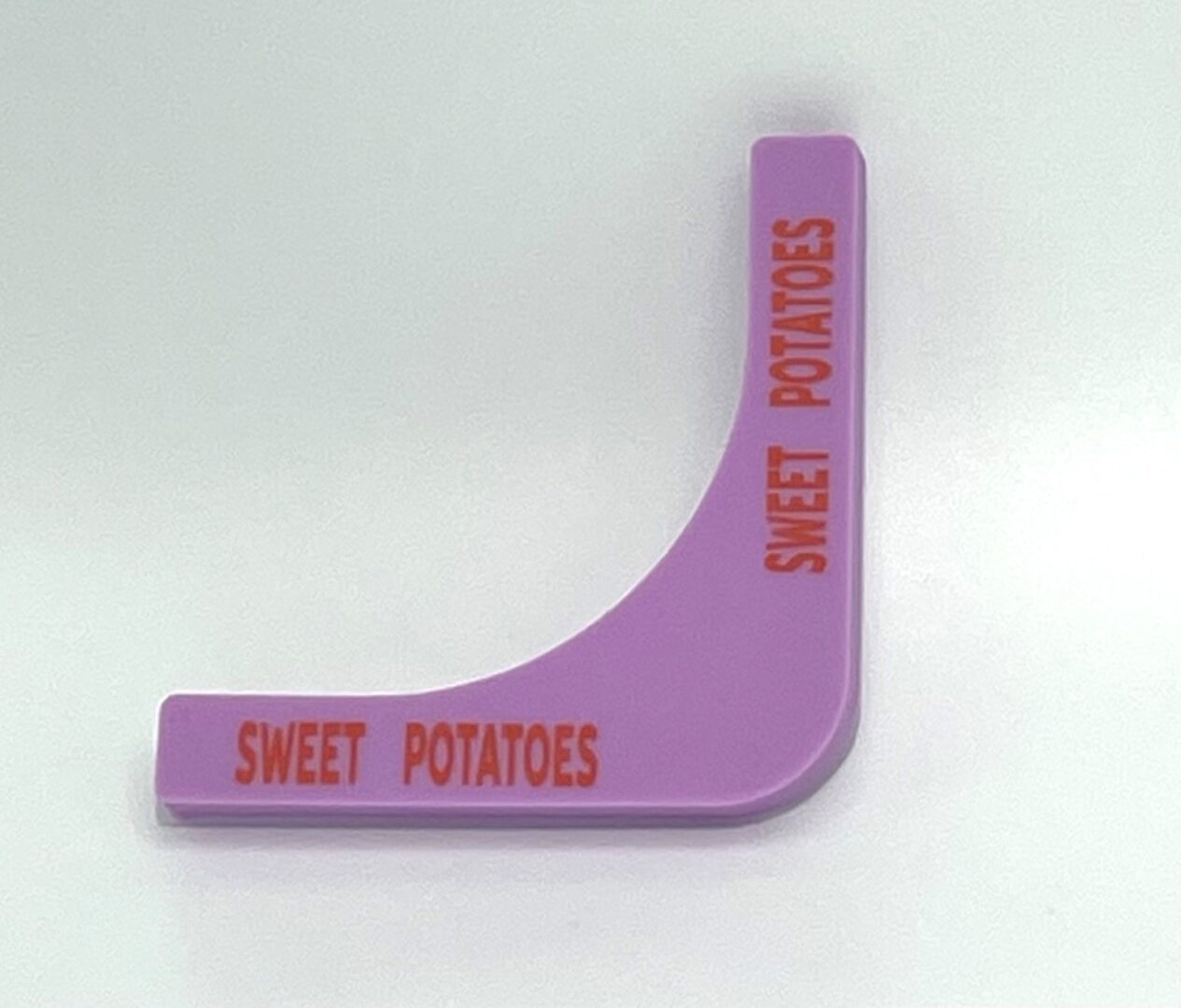 A purple plastic wedge with the words " sweet potatoes ".