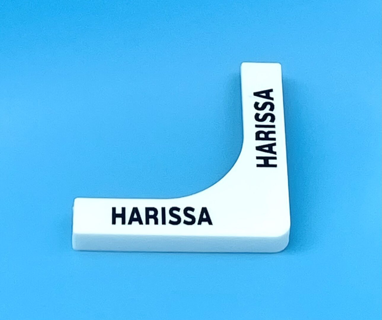 A white plastic object with the name harissa written on it.