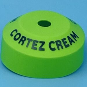 A green plastic cap with the name cortez cream written on it.