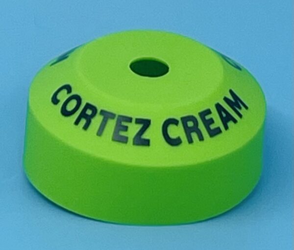 A green plastic cap with the name cortez cream written on it.