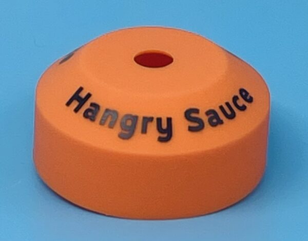 A orange bottle cap with the words " hangry sauce ".