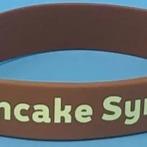 A brown wristband with the words pancake syrup written on it.