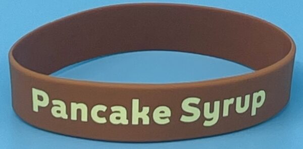 A brown wristband with the words pancake syrup written on it.