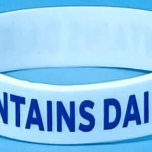 A white wristband with the words mountains daily written on it.