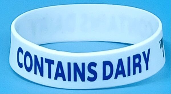 A white wristband with the words mountains daily written on it.