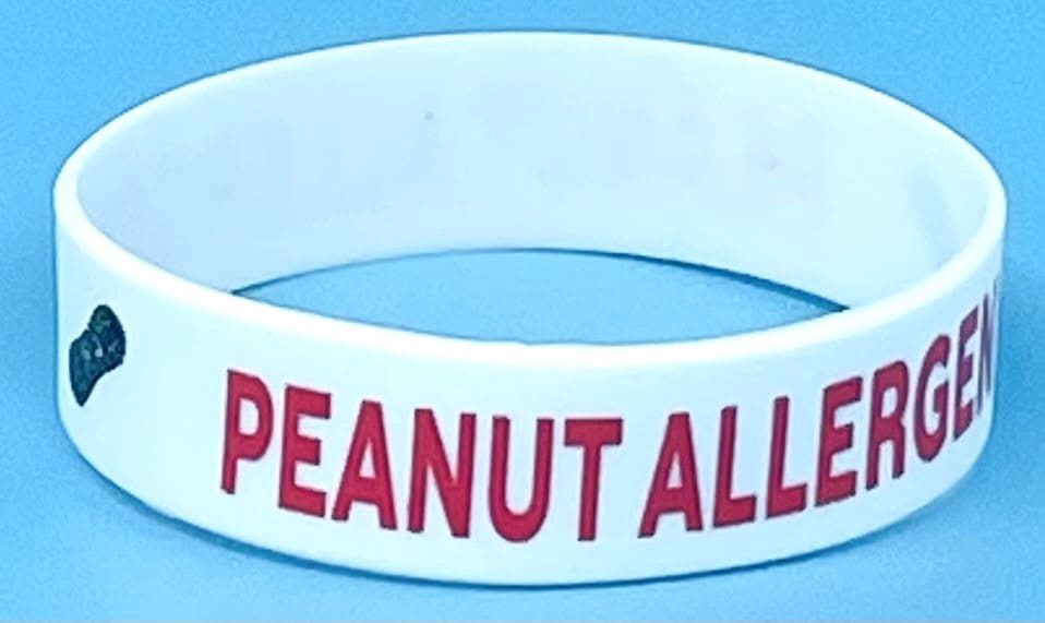 A peanut allergy wristband is shown on the table.