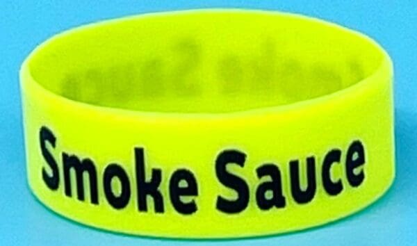 A neon yellow smoke sauce wristband with the words " smoke sauced ".