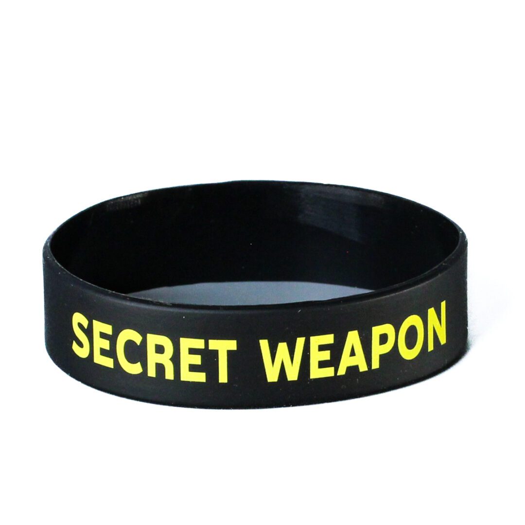 A black and yellow bracelet with the words " secret weapon ".