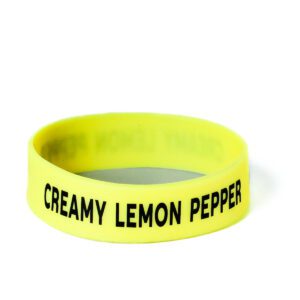 A yellow bracelet with the words creamy lemon pepper on it.