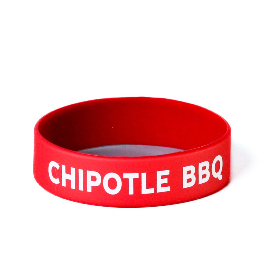 A red chipotle bbq wristband with white lettering.