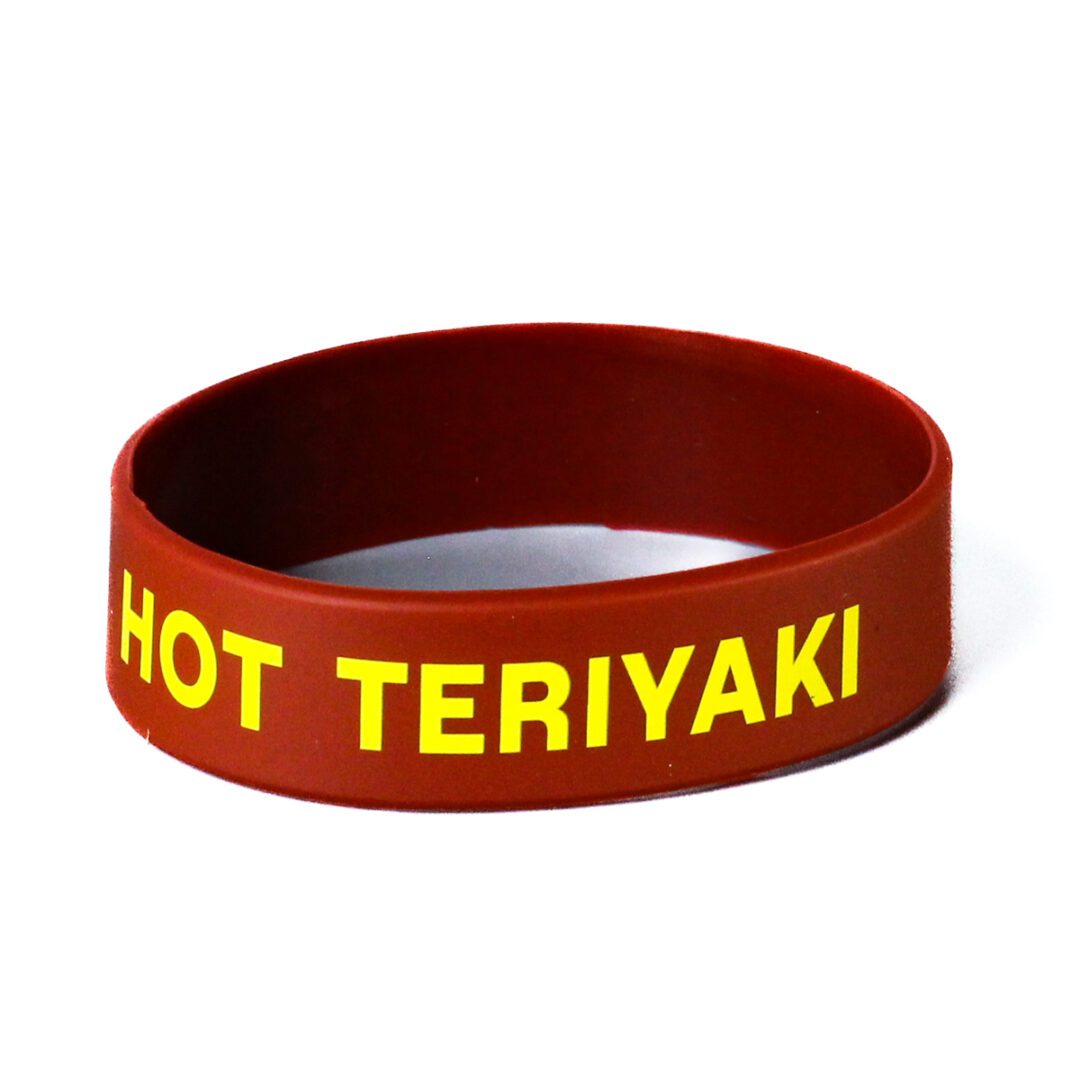 A red and yellow wristband with the words hot teriyaki written on it.