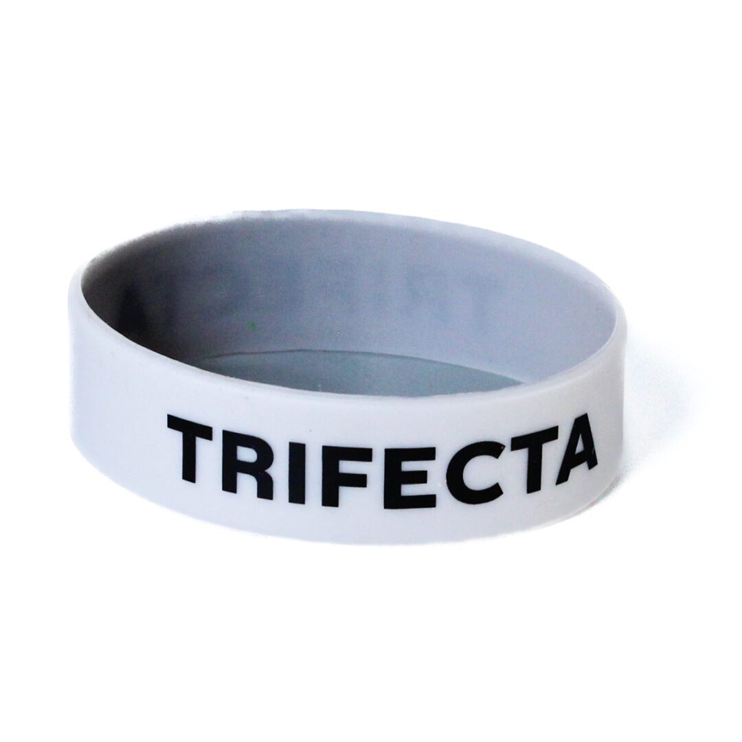 A white bracelet with the word trifecta written on it.