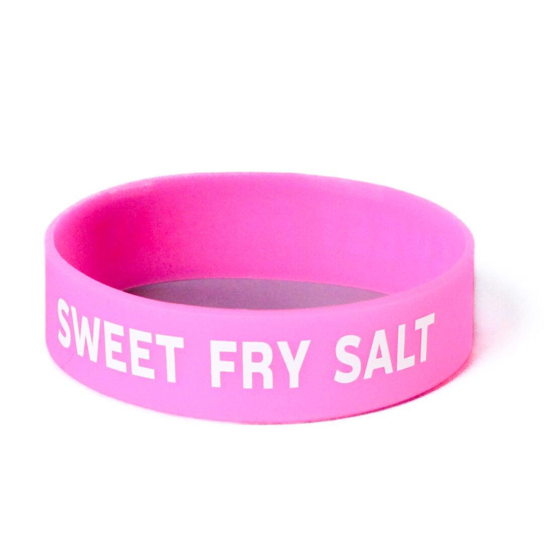 A pink wristband with the words " sweet fry salt ".