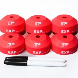 A group of six red caps sitting next to two white markers.