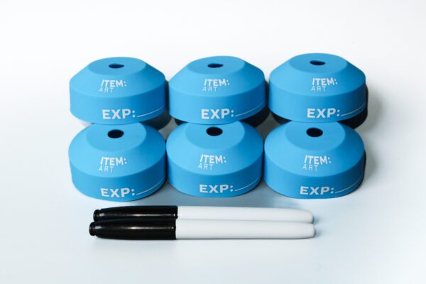 A group of six blue caps with markers on top.