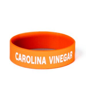 A orange wristband with the words " carolina vinegar ".