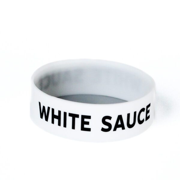 A white bracelet with the words " white sauce ".