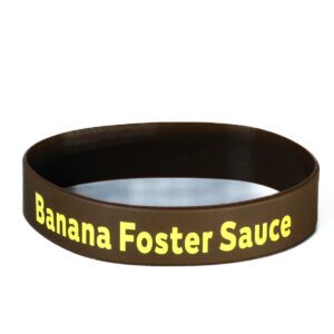 A brown and yellow wristband with the words " banana foster sauce ".