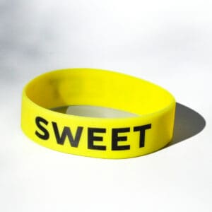 Yellow bracelet with "SWEET" text.