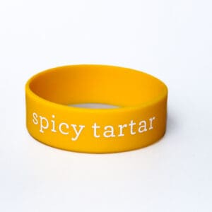 Yellow wristband with "spicy tartar" text.