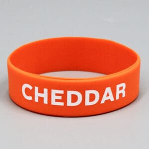 Orange wristband with "CHEDDAR" text.