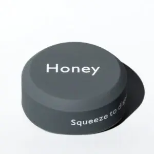 Black honey bottle cap on white background.