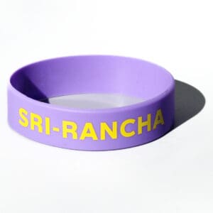 Purple wristband with yellow "SRI-RANCHA" text.