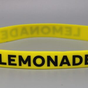 Yellow wristband with "LEMONADE" text.