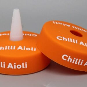 Orange Chilli Aioli bottle caps on display.