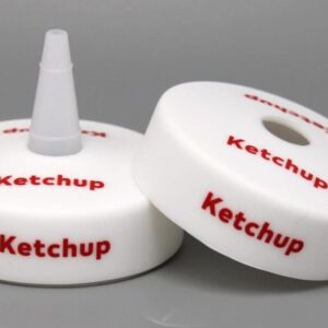 Ketchup bottle caps on gray background.