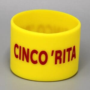 Yellow bracelet with "CINCO 'RITA" in red.