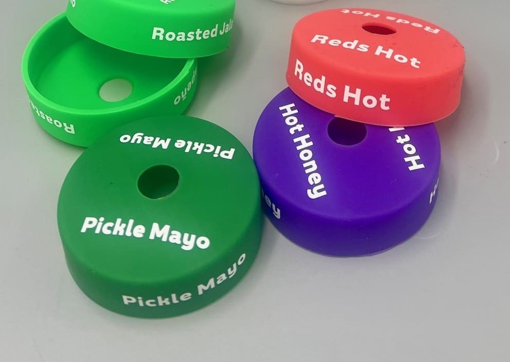 Colorful sauce labels on a gray surface.
