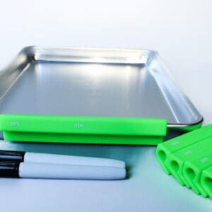Metal tray with markers and green clips.